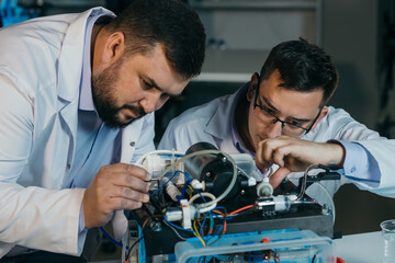 Two scientists are working on the development of a new device