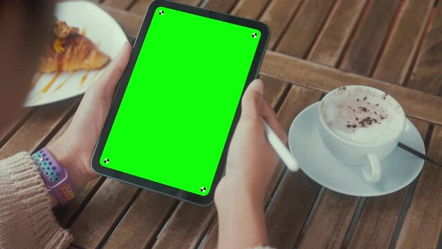 women holding digital tablet green screen on table