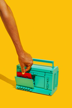 man inserting a tape into a radio cassette