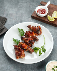 Roasted chicken wings with spices. Served with sauce