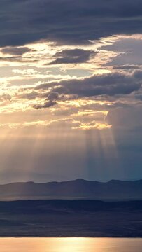 Sun rays shining through the clouds during timelapse in Utah along Utah Lake.