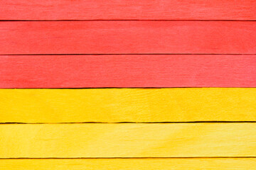 Art wooden textured background. Yellow and red painted wooden boards are arranged horizontally. Bright detailed wooden background or texture.