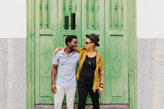 Young couple standing near entrance of old colonial building