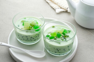 Buko Pandan, a dessert from Philippines, made from jelly, young coconut, evaporated milk, sweetened condensed milk, and ice. Served on glass with cheese topping. 
