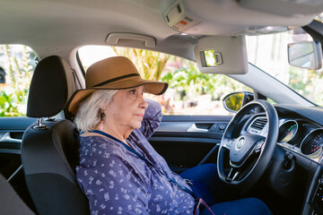 Senior female driver waiting inside car