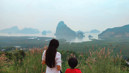 Thai mother and son with views of Samet Nangshe, a tourist destination in the south of Thailand.