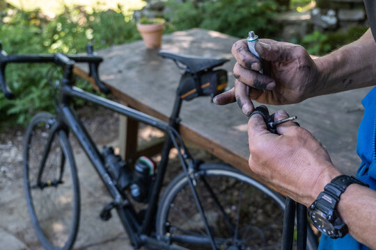 man is putting a glue a punctured tire on his bicycle