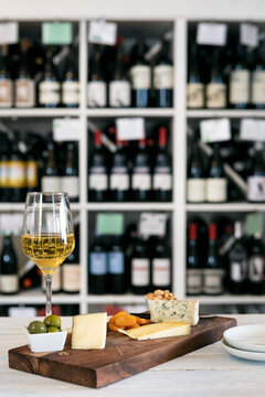 Sampling Of Cheeses On A Board With White Wine