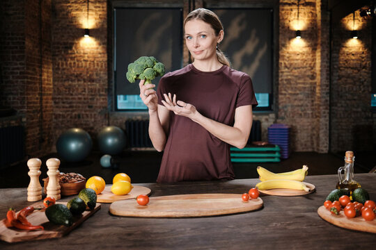 Fitness Trainer Demonstrating Fresh Broccoli