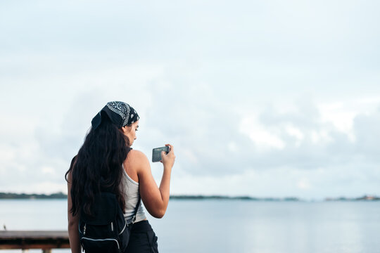 woman taking photos with the smartphone to a beautiful seascape