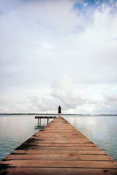 Beautiful shot of a woman alone on a wooden jetty