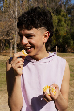 Man in the park eating tangerines