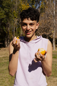 Man in the park eating tangerines