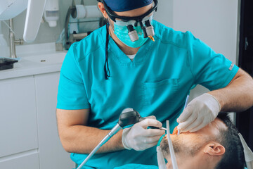 Dentist using various instruments on patient teeth 