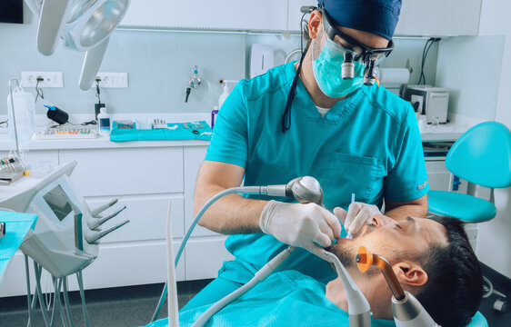 Dentist using various instruments on patient teeth 
