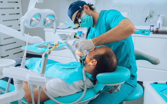 Dentist and patient in ordination during dental examination.