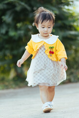 little girl walking in yellow dress