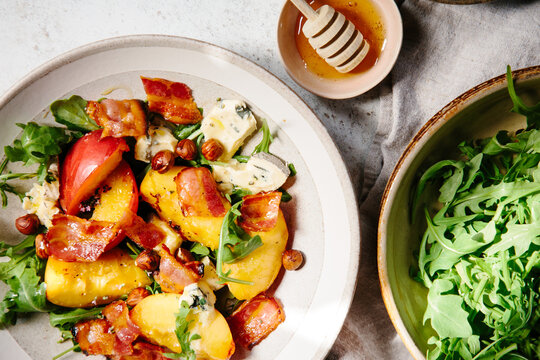 A dish of cooked peaches with blue cheese and bacon