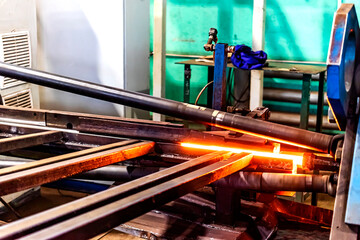 Machine for induction heating of metal. A metal rod heated in an induction furnace. Hot metal...