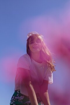 Young Model Posing Against Blue Sky With Pink Bokeh