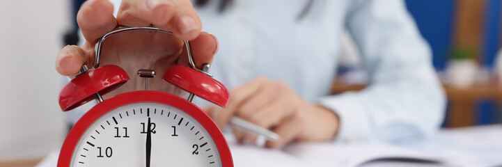 Woman turn off timer on clock at eight oclock in morning, time start work