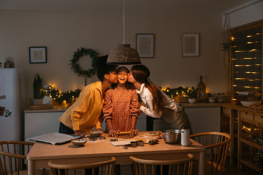Lesbian couple with their daughter preparing Christmas cookies