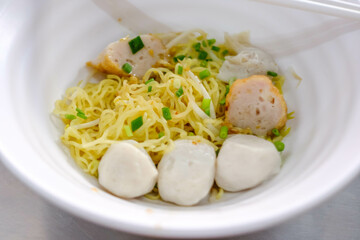 Yellow noodle with fish meatballs and soup.
