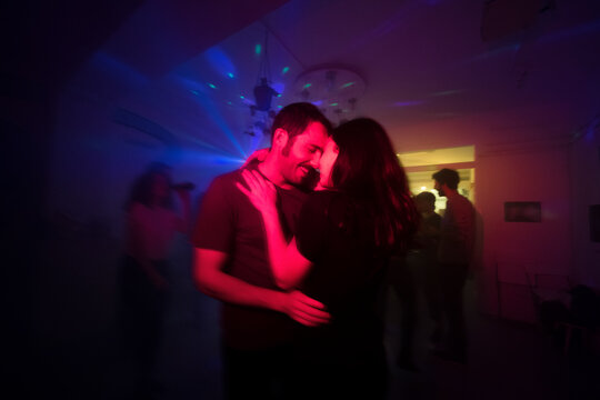 Intimate couple moment during night party