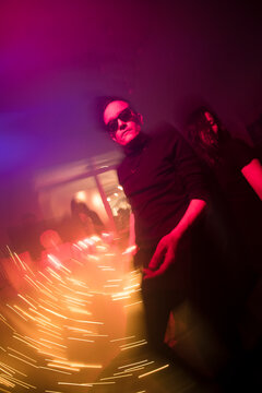 Cool man dancing at the party with colour lights 