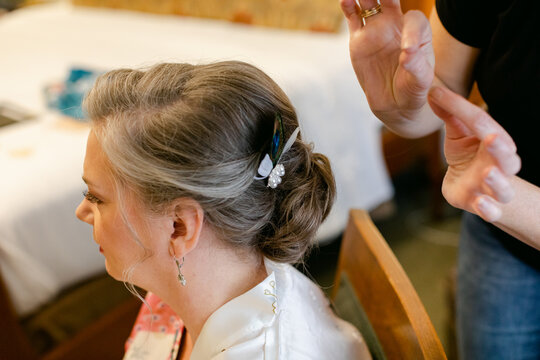 A Stylist Places an Accessory in a Bride's Hair