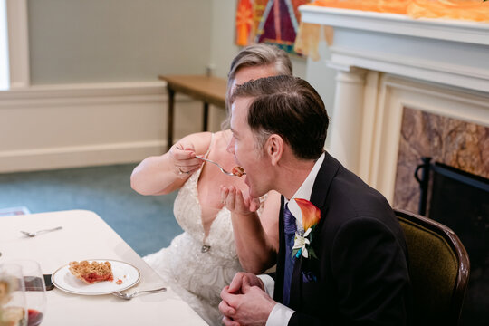 Bride Feeding Her Groom a Piece of Pie on their Wedding Day