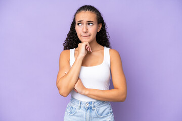 Young woman isolated on purple background having doubts and thinking