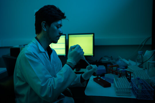Scientist Working In A Dark Laboratory Next To The Computer.
