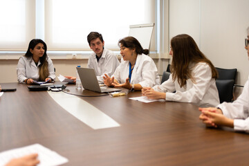 Meeting Of Scientists Discussing Sitting Around The Table.