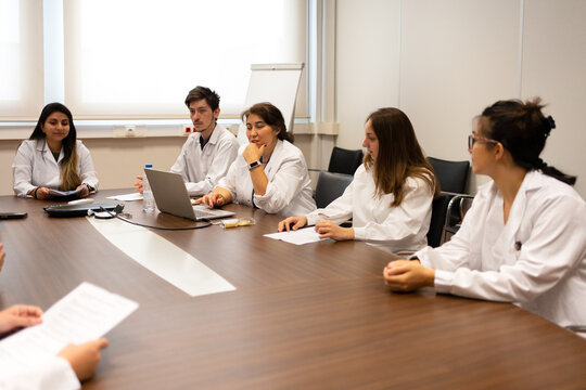 Meeting Of Scientists Discussing Sitting Around The Table.
