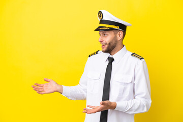 Airplane caucasian pilot isolated on yellow background with surprise facial expression