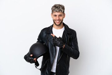 Young man with a motorcycle helmet isolated on white background pointing to the side to present a product