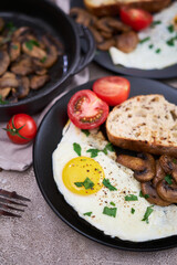 Close up view of the fried egg, mushrooms and bread on a frying pan