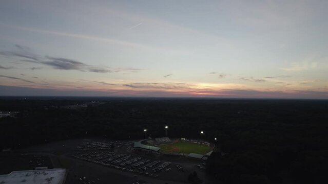 Aerial view of stadium in the night with full parking lot against twilight sky