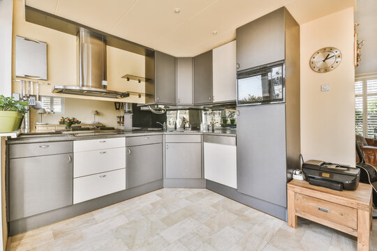 Kitchen with chrome built in appliances and grey cabinets