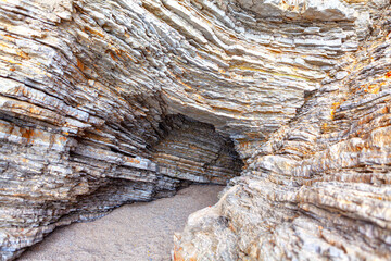 Grotto in sedimentary rocks . Natural cavern in the cliff