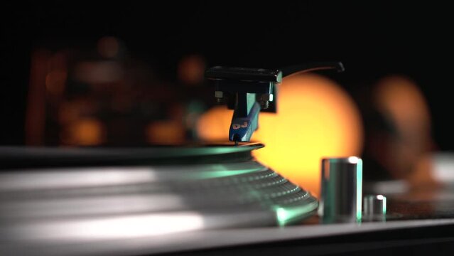 Hand Placing Needle and Tonearm of Gramophone on Spinning Vinyl Record, Close Up