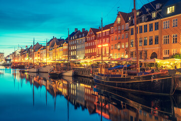 Fototapeta na wymiar Beautiful view with colorful facade of traditional houses and old wooden ships along the Nyhavn Canal or New Harbour, canal and entertainment district, night view