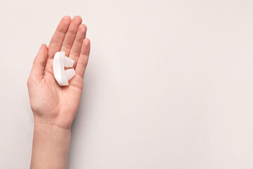Woman holding anti-snoring device on light grey background, top view. Space for text