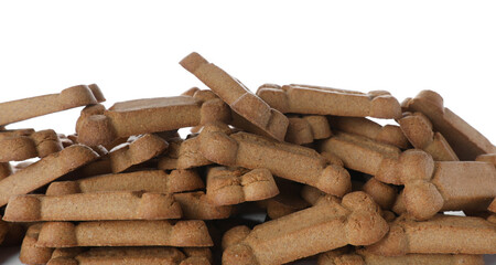 Pile of bone shaped dog cookies on white background, closeup