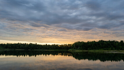 Aerial view, shot by a drone of a sunset at coast of the lake. Nature landscape. Nature in northern Europe. reflection, blue sky and yellow sunlight. landscape during sunset. High quality photo