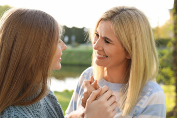Happy mother with her daughter spending time together in park on sunny day
