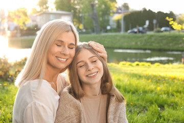 Happy mother with her daughter spending time together in park on sunny day