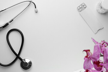 Stethoscope, pills and orchid flower on white background, flat lay with space for text. Women's...
