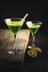FResh and tasty kiwi cocktail on wooden background